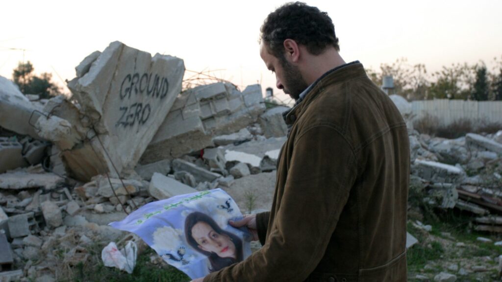 Amin looks at his wife's likeness on a poster in the West Bank