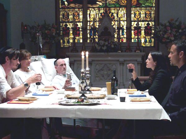 Jonathan (Hedlund), Rachel (Archer), Robert (Jenkins), Karen (Brown-Findlay) and a police officer (Daniel Sunjata) at the Passover Seder
