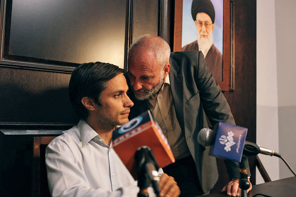 Rosewater (Kim Bodnia) whispers into Maziar's (Bernal) ear just before his statement on TV