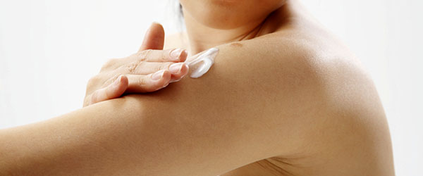 WOMAN EXFOLIATING ARMS/PUTTING ON LOTION