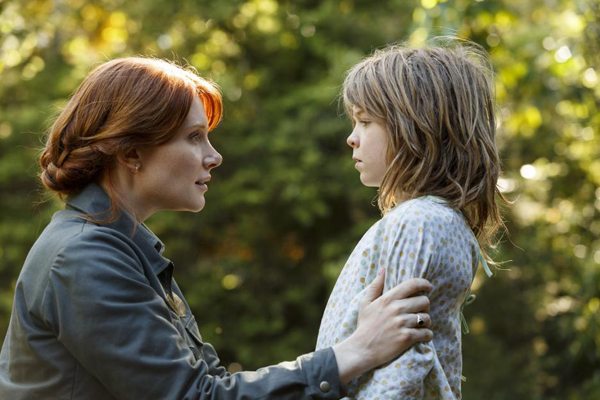 Grace (Bryce Dallas Howard) comforts Pete (Oakes Fegley) in PETE'S DRAGON