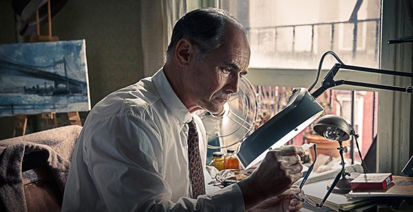 Rudolph Able (Mark Rylance) looks over a newspaper for information to pass on to the Russians